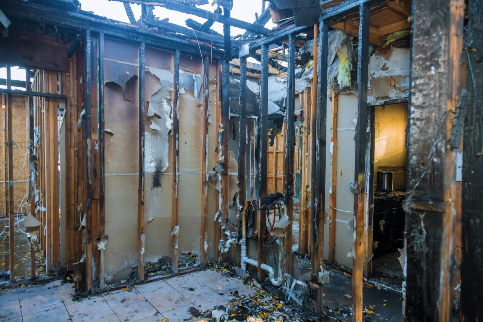 Fire-damaged house interior, charred walls.
